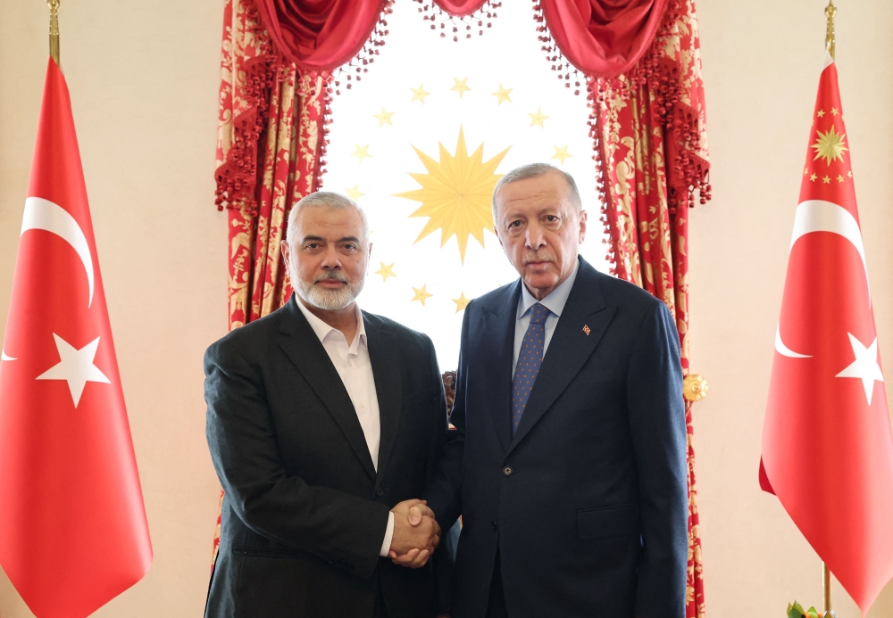 (Files) This handout photograph taken and released by Turkish Presidency Press Office on April 20, 2024, shows Turkish President Recep Tayyip Erdogan (R) shaking hands with Ismail Haniyeh, the political leader of the Palestinian movement Hamas. (Photo by Handout / Turkish Presidential Press Service / AFP)