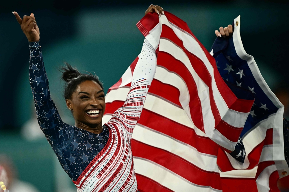 US' Simone Biles celebrates after team USA won the artistic gymnastics women's team final during the Paris 2024 Olympic Games at the Bercy Arena in Paris, on July 30, 2024. (Photo by Loic Venance / AFP)