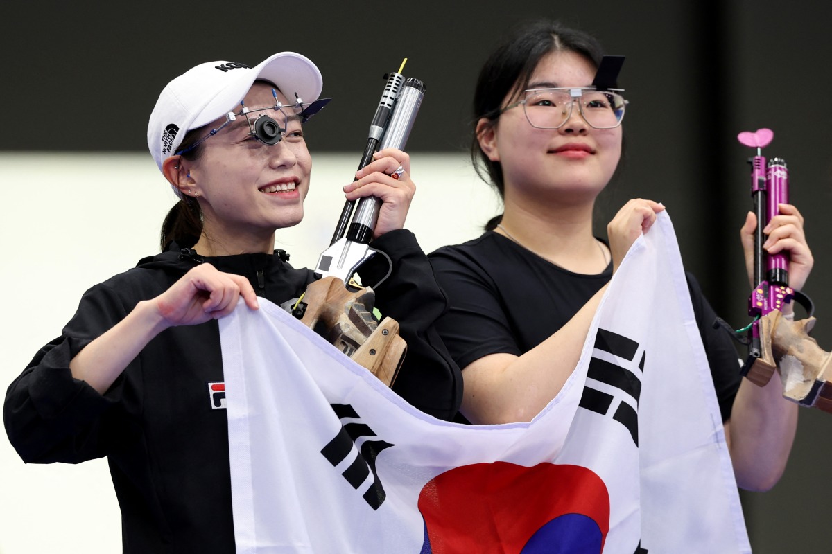 Silver medalist, South Korea's Kim Ye-ji (L) and gold medalist South Korea's Oh Ye Jin, react at the end of the 10m air pistol women's Final during the Paris 2024 Olympic Games at Chateauroux Shooting Centre on July 28, 2024. (Photo by Alain Jocard / AFP)