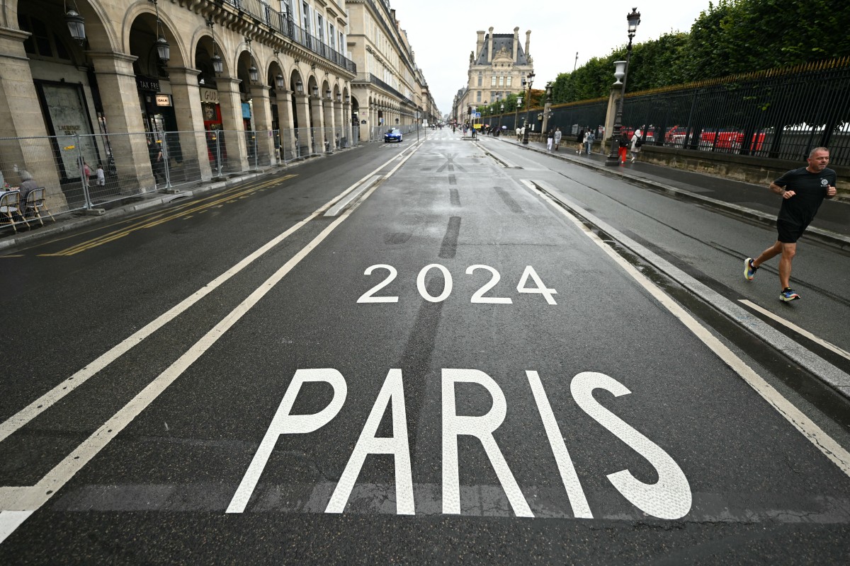 A man runs along Rue de Rivoli, which has been temporarily blocked off due to the Paris 2024 Olympic Games, in Paris on July 27, 2024. (Photo by Kirill KUDRYAVTSEV / AFP)
