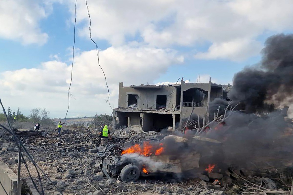 Lebanese civil defence workers search the scene as vehicles burn following an Israeli air raid on the town of Shamaa (Chamaa) in southern Lebanon on August 1, 2024. Photo by KAWNAT HAJU / AFP.