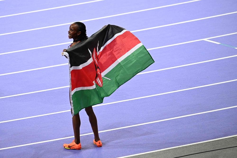 Kenya's Beatrice Chebet celebrates after winning the women's 5000m final of the athletics event at the Paris 2024 Olympic Games at Stade de France in Saint-Denis, north of Paris, on August 5, 2024. (Photo by MARTIN BERNETTI / AFP)
