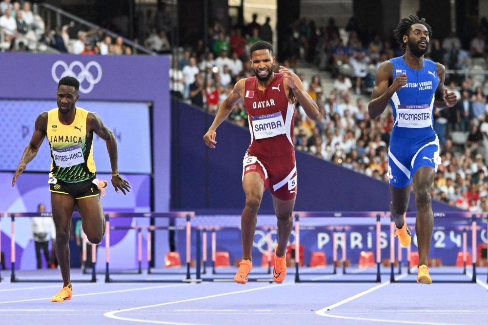 Jamaica's Malik James-King, Qatar's Abderrahman Samba and British Virgin Islands' Kyron McMaster compete in the men's 400m hurdles semi-final of the athletics event at the Paris 2024 Olympic Games at Stade de France in Saint-Denis, north of Paris, on August 7, 2024. (Photo by Jewel Samad / AFP)
