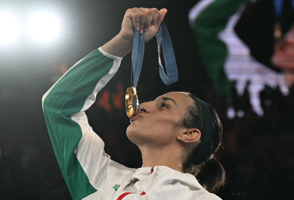 Gold medallist Algeria's Imane Khelif poses on the podium during the medal ceremony for the women's 66kg final boxing category during the Paris 2024 Olympic Games at the Roland-Garros Stadium, in Paris on August 9, 2024. (Photo by MOHD RASFAN / AFP)