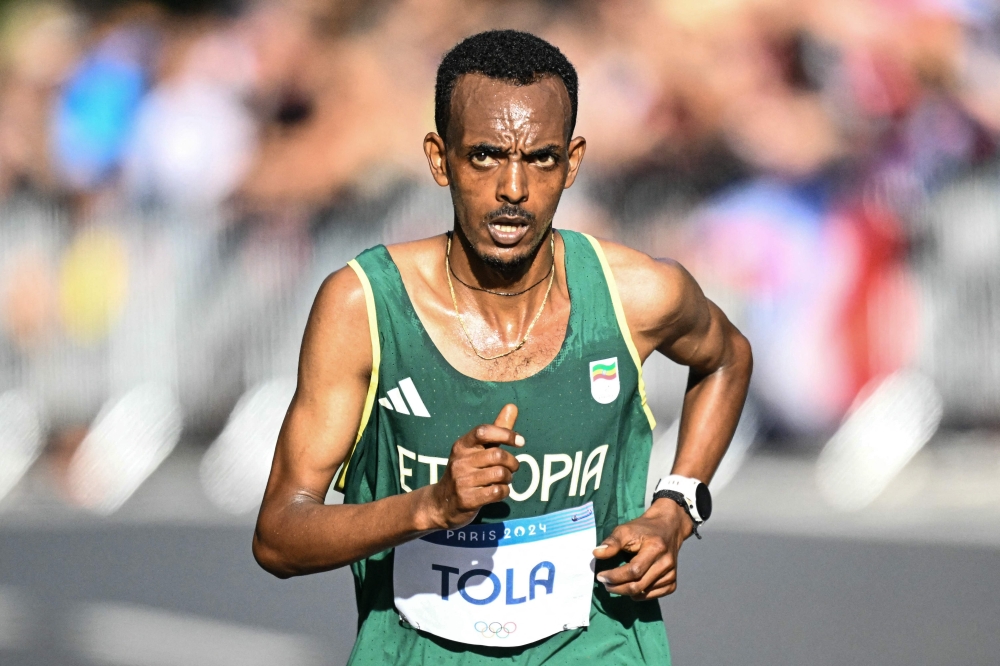 Ethiopia's Tamirat Tola runs on a road from Versailles to Paris in the men's marathon of the athletics event at the Paris 2024 Olympic Games on August 10, 2024. (Photo by Kirill KUDRYAVTSEV / AFP)