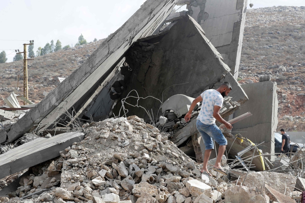 A man inspects the damage to a building after an Israeli strike in the southern town of Kfour, in the Nabatiyeh district, on August 17, 2024. Photo by Mahmoud ZAYYAT / AFP