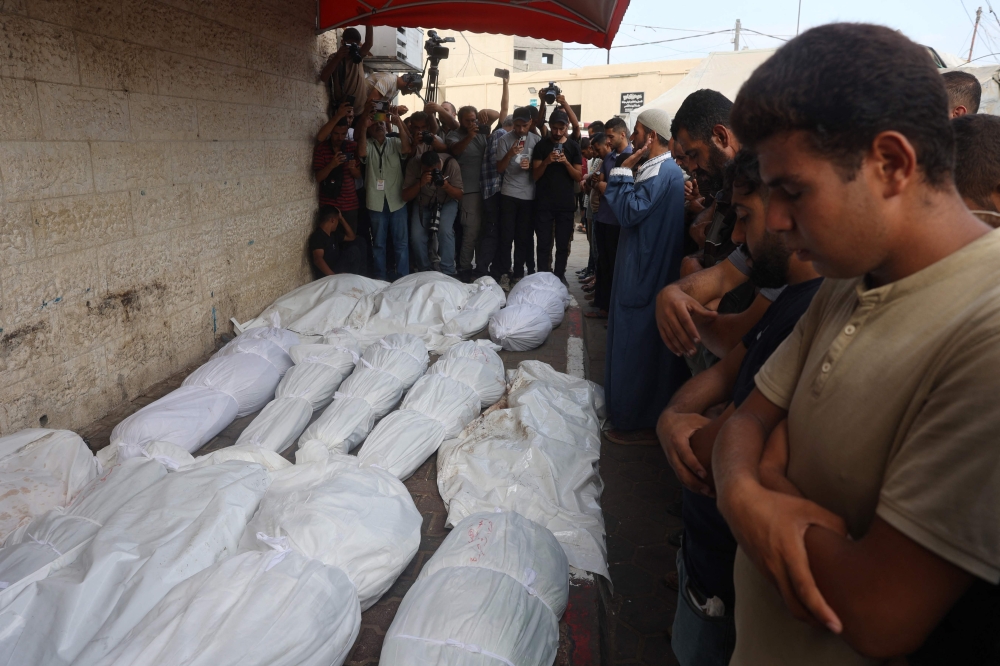 Palestinians mourn their relatives, killed in an Israeli strike, at the Al-Aqsa Martyrs hospital in Deir el-Balah in the central Gaza Strip on August 17, 2024. (Photo by Eyad BABA / AFP)
