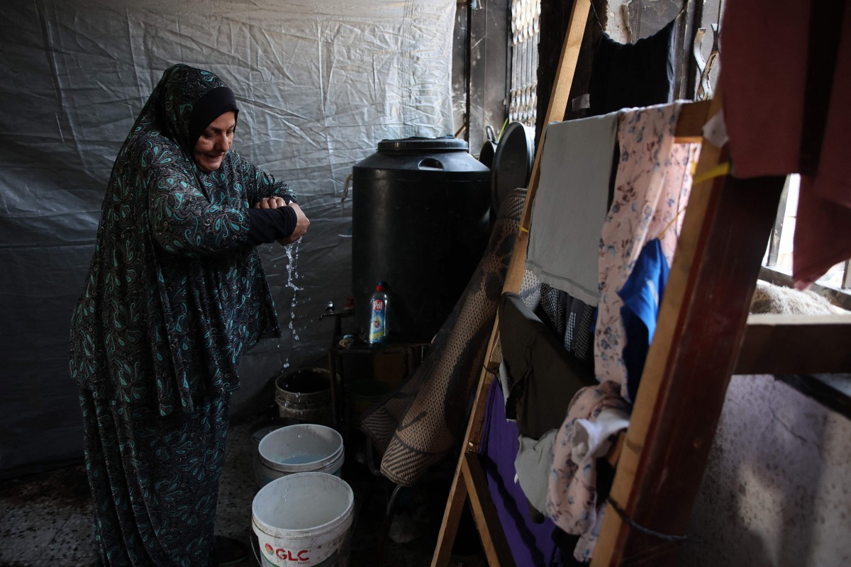 Displaced Palestinian Nazek Abu Shmala washes clothes inside a flat in the Jabalia refugee camp in the northern Gaza Strip where she's temporarily sheltering with her family on August 15, 2024,amid the conflict between Israel and Hamas militants. (Photo by Omar AL-QATTAA / AFP)