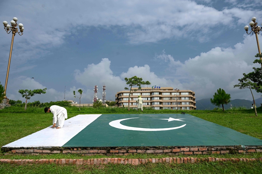 People work near the Pakistan Telecommunication Authority (PTA) headquarters building in Islamabad on August 16, 2024. (Photo by Aamir Qureshi / AFP)

