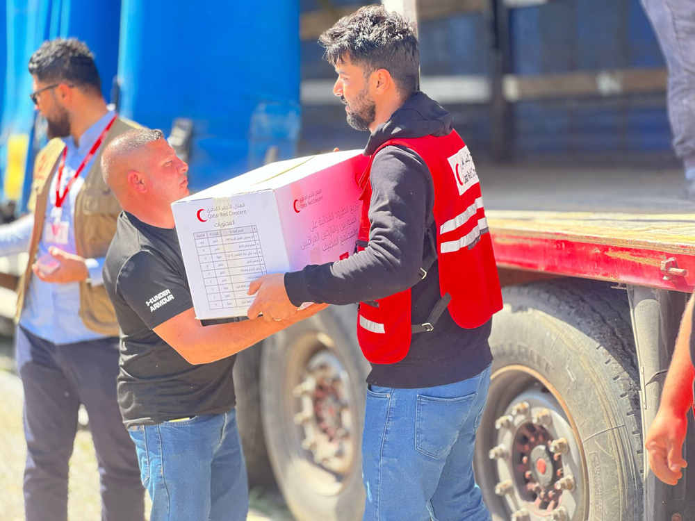 File photo: A QRCS staff distributes food items during one of their international outreach. 