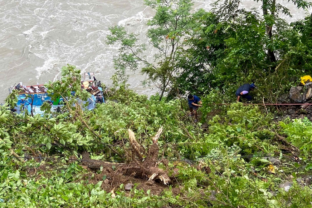 Rescue personnel gather at the site after a bus carrying Indian passengers plunged into the Marsyangdi river in Nepal's Tanahun district on August 23, 2024. (Photo by SHANKHAR ADHIKARI / AFP)
