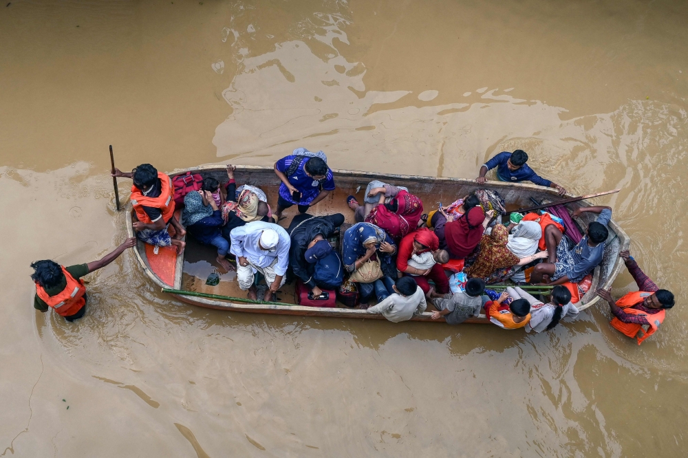 Volunteers rescue flood-affected residents in Feni, in south-eastern Bangladesh, on August 23, 2024. (Photo by Munir Uz Zaman / AFP)

