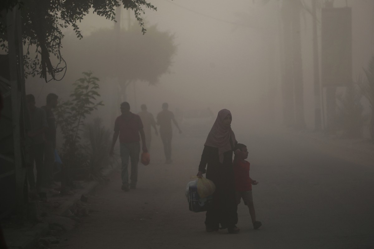 Palestinians find their way amid the dust and smoke after Israeli troops targeted a building in the Nuseirat refugee camp in the central Gaza Strip on August 22, 2024. Photo by Eyad BABA / AFP.