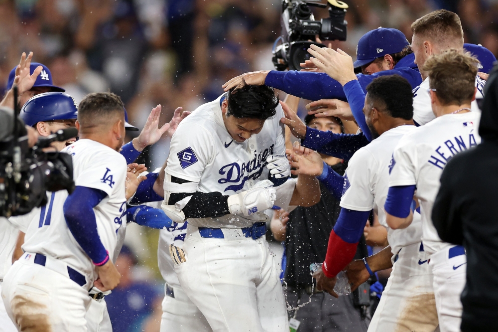 Shohei Ohtani #17 of the Los Angeles Dodgers celebrates with teammates after hitting a walk-off grand slam home run during the ninth inning against the Tampa Bay Rays at Dodger Stadium on August 23, 2024 in Los Angeles, California. (Photo by Katelyn Mulcahy / GETTY IMAGES NORTH AMERICA / Getty Images via AFP)
