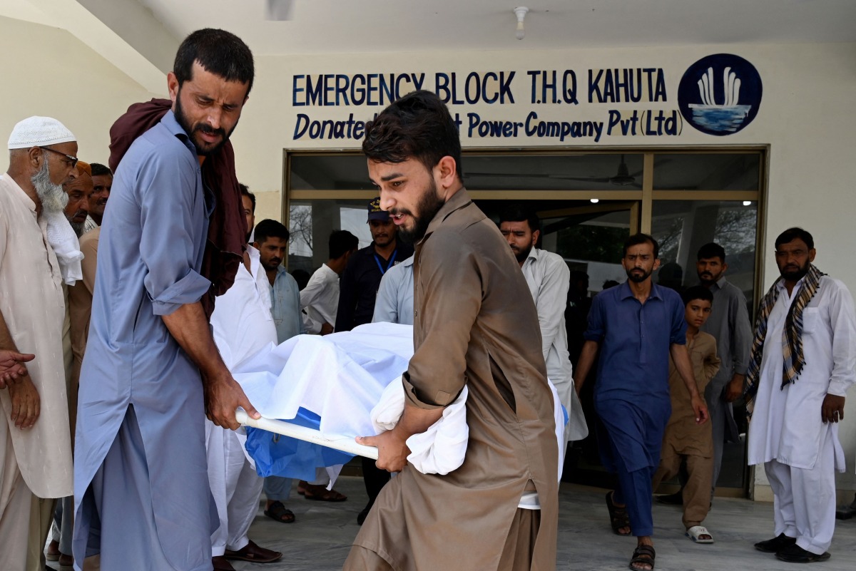 People move the body of a bus accident victim from a hospial in Kahuta, Punjab province on August 25, 2024. (Photo by Aamir QURESHI / AFP)