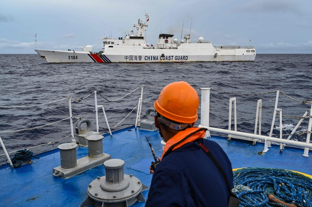 A China Coast Guard ship is seen from the Philippine Coast Guard vessel BRP Cabra during a supply mission to Sabina Shoal in disputed waters of the South China Sea on August 26, 2024. (Photo by Jam Sta Rosa / AFP)