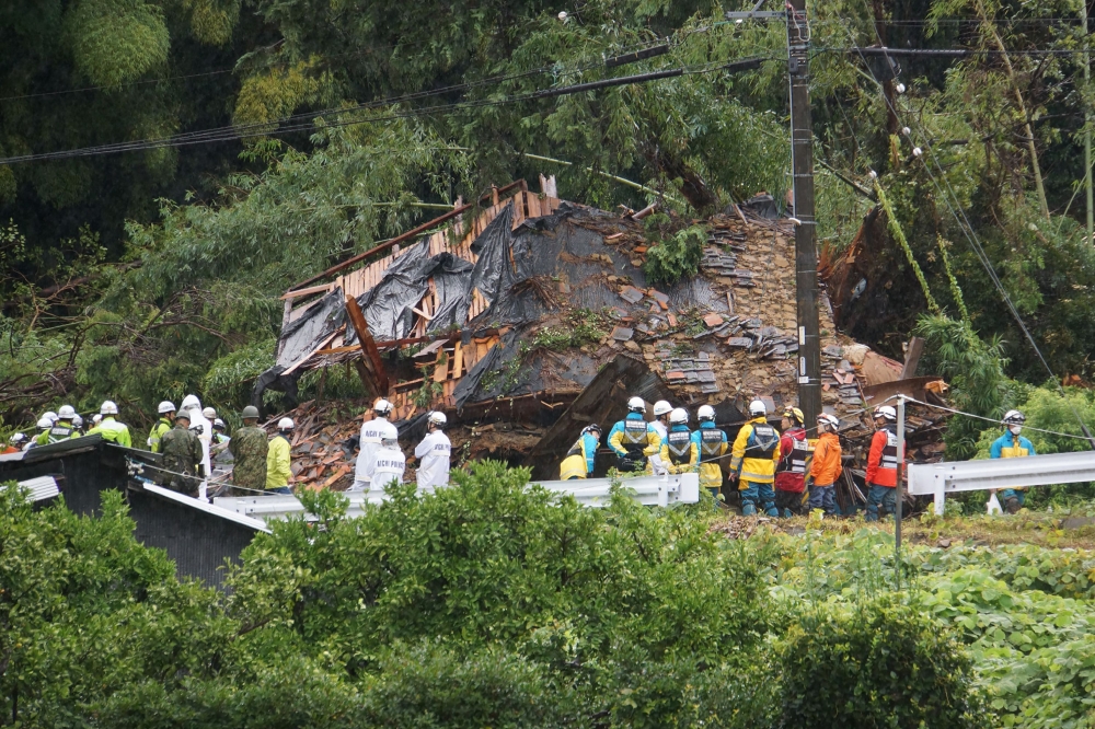 This photo shows rescue workers outside a house that was hit by a landslide in Gamagori, Aichi prefecture on August 28, 2024. Photo by JIJI Press / AFP