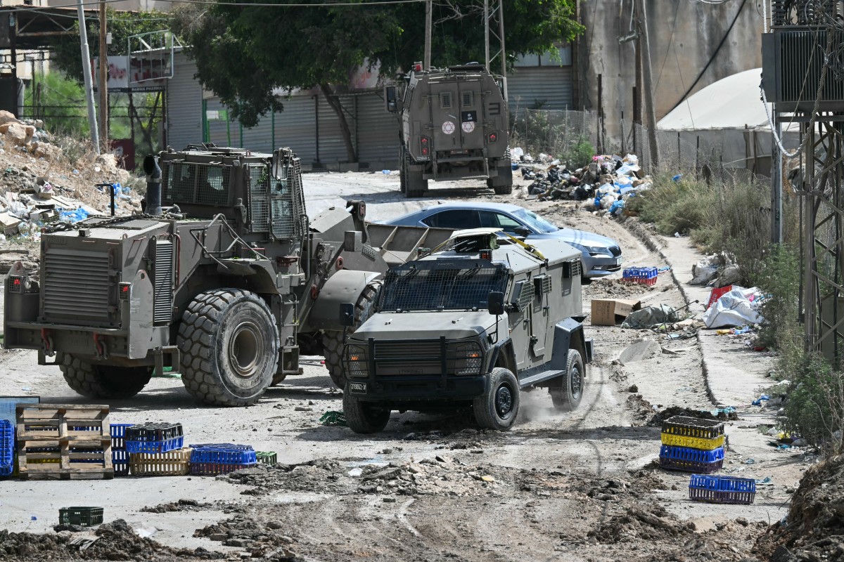 Israeli military armoured vehicles including a bulldozer block a road during a raid in the al-Faraa camp for Palestinian refugees near Tubas city in the occupied West Bank on August 28, 2024. Photo by RONALDO SCHEMIDT / AFP.