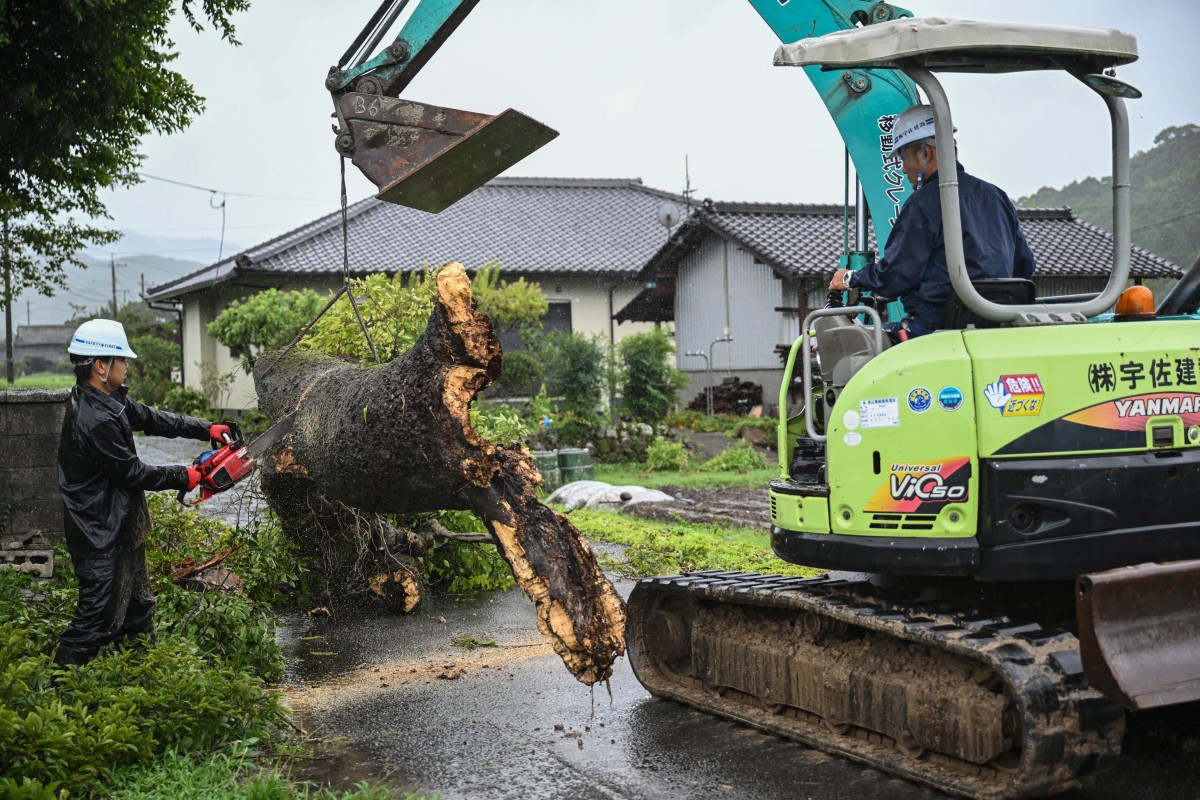 Workers remove a fallen tree brought down by strong winds from Typhoon Shanshan in Usa, Oita prefecture on August 29, 2024. Photo by Yuichi YAMAZAKI / AFP