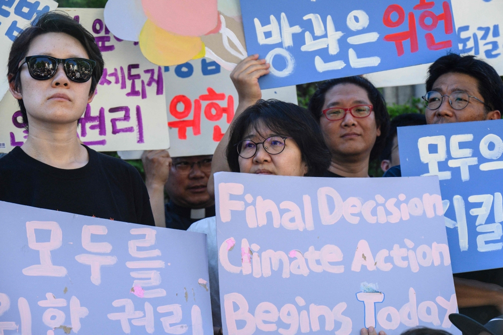 Climate activists hold banners outside South Korea's Constitutional Court in Seoul on August 29, 2024. Photo by ANTHONY WALLACE / AFP