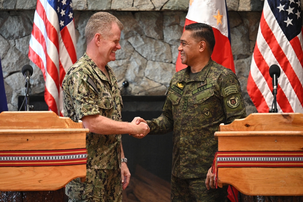 Philippines' Military Chief General Romeo Brawner (R) shakes hands with US Indo-Pacific Commander Admiral Samuel Paparo during a joint press conference after the Philippines-US Mutual Defence Board meeting at the Philippine Military Academy in Baguio on August 29, 2024. Photo by Ted ALJIBE / AFP