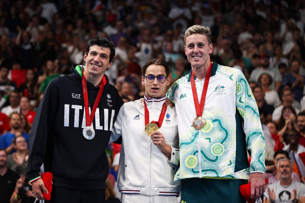 (From left) Silver medalist Italy's Simone Barlaam, gold medalist France's Ugo Didier and bronze medalist Australian Brenden Hall celebrate on the podium of the men's S9 400m freestyle swimming event during the Paris 2024 Paralympic Games at The Paris La Defense Arena in Nanterre, west of Paris on August 29, 2024. (Photo by Franck Fife / AFP)