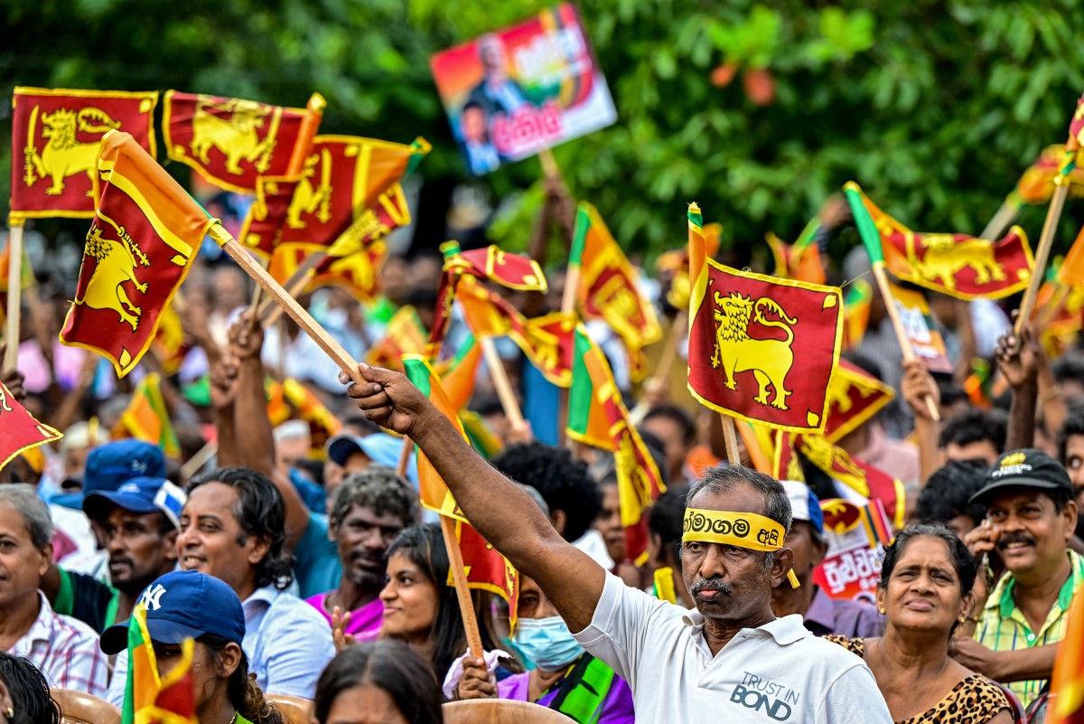 Supporters of Sri Lanka's president and United National Party presidential candidate Ranil Wickremesinghe, wave the country's national flag during an election rally ahead of the upcoming presidential elections in Colombo on August 28, 2024. Photo by Ishara S. KODIKARA / AFP.