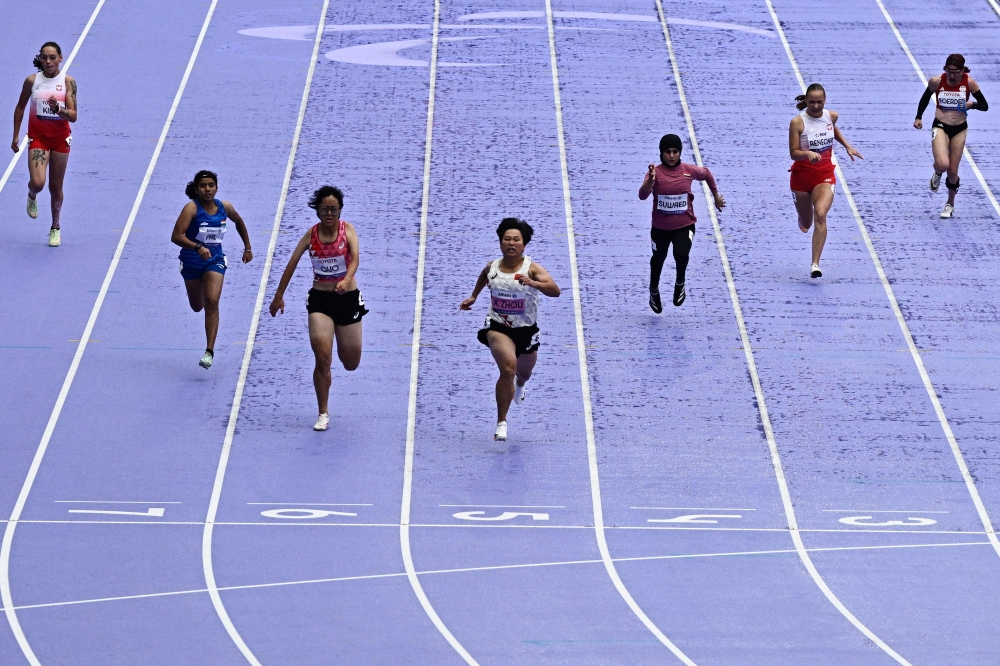 Chinese gold medallist Zhou Xia (centre) during the women's T35 100m final athletics event at the Stade de France in Saint-Denis, north of Paris on August 30, 2024, during the Paris 2024 Paralympic Games. (Photo by Julien De Rosa / AFP)