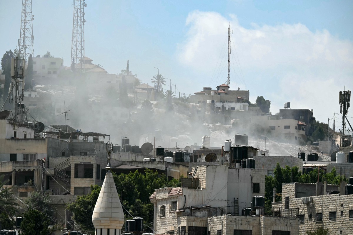 Smoke rises above buildings during an Israeli occupation army raid in Jenin in the occupied-West Bank on August 31, 2024. Photo by RONALDO SCHEMIDT / AFP.
