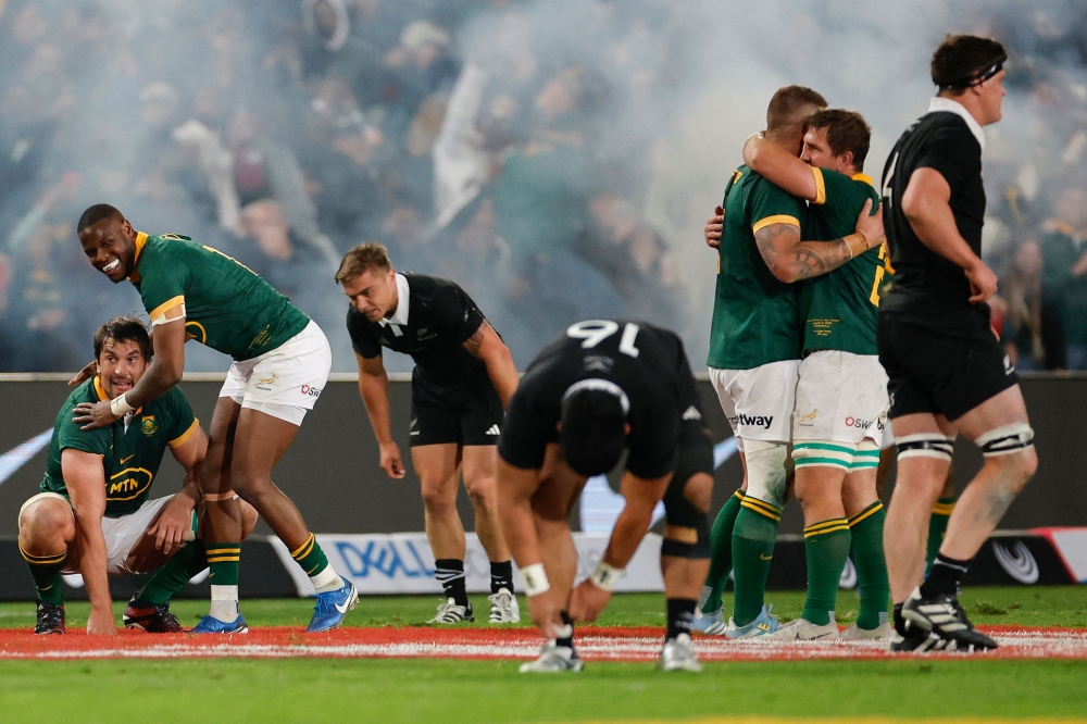 South Africa's loose forward Eben Etzebeth (L) and South Africa's full-back Aphelele Fassi (2nd L) celebrate after South Africa won the Rugby Championship Test match between South Africa and New Zealand at the Ellis Park Stadium in Johannesburg on August 31, 2024. (Photo by PHILL MAGAKOE / AFP)
