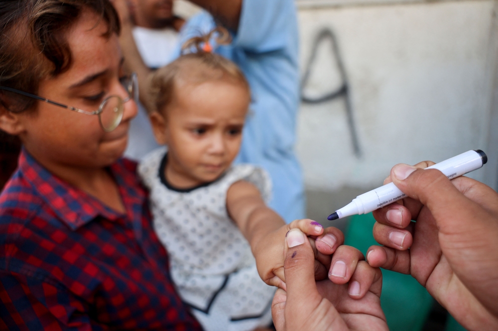 A health worker marks the finger of a Palestinian child that was vaccinated against Polio in Zawayda in the central Gaza Strip on September 1, 2024. Photo by Eyad BABA / AFP