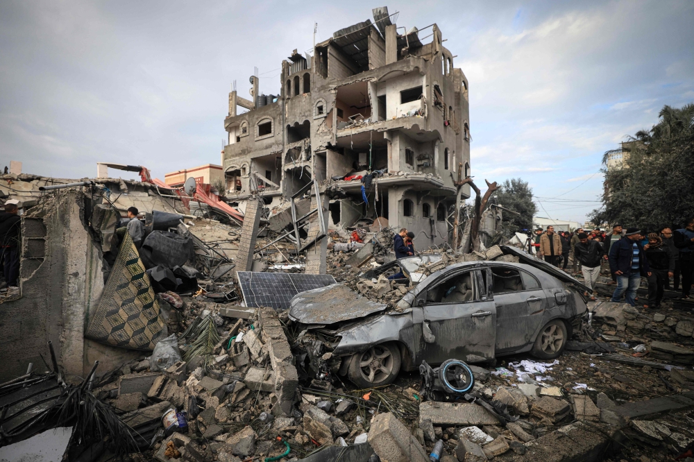 File: Palestinians inspect the damage at the Al-Maghazi refugee camp after an overnight Israeli strike on December 25, 2023. (Photo by Mahmud Hams / AFP)
