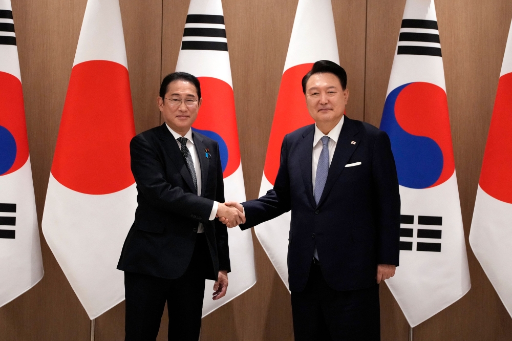 South Korea's President Yoon Suk Yeol (R) and Japan's Prime Minister Fumio Kishida shake hands during a meeting at the Presidential Office in Seoul on September 6, 2024. (Photo by Lee Jin-man / POOL / AFP)