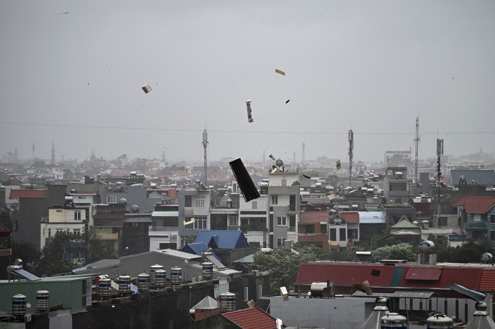 Debris flies in the air as heavy rain and high winds from Super Typhoon Yagi impact Hai Phong on September 7, 2024. (Photo by NHAC NGUYEN / AFP)