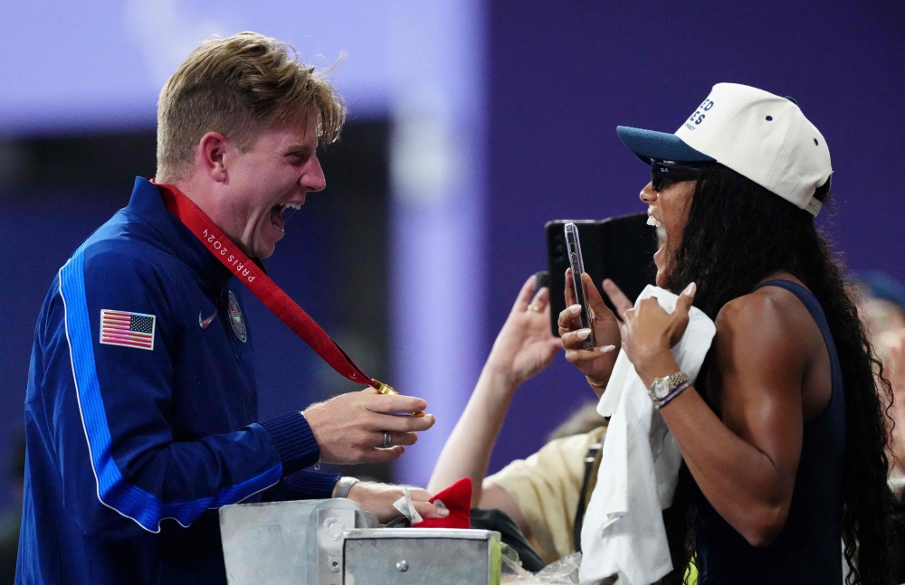 Gold medallist US' Hunter Woodhall (L) celebrates with his wife Olympic women's long jump champion Tara Davis-Woodhall after the victory ceremony for the Men's 400m T62 final event at the Stade de France in Saint-Denis, outside Paris on September 6, 2024. (Photo by Dimitar DILKOFF / AFP)