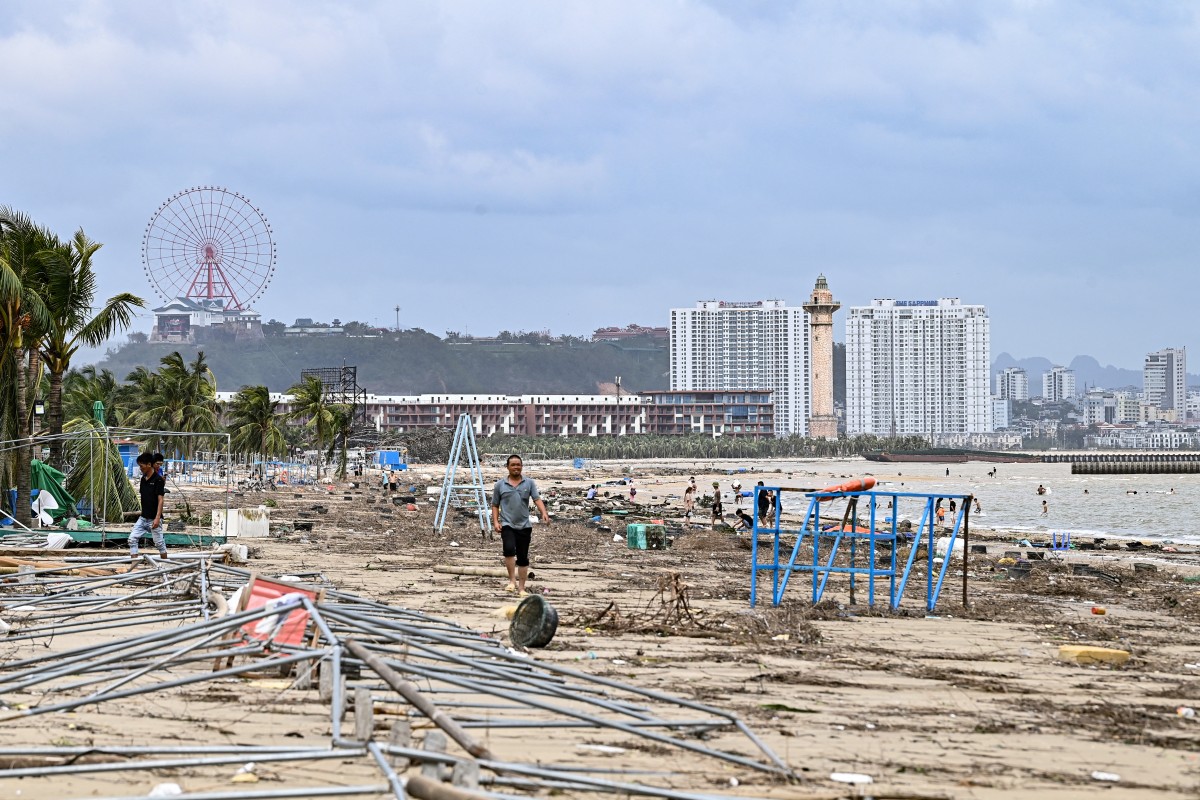 People walk amid debris on Bai Chay beach after Super Typhoon Yagi hit Ha Long, in Quang Ninh province, on September 8, 2024. Photo by NHAC NGUYEN / AFP