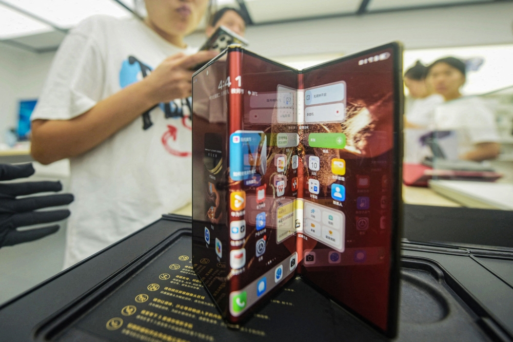 Chinese tech giant Huawei's new trifold phone Huawei Mate XT is displayed during its launch day at a Huawei store in eastern China's Zhejiang province on September 10, 2024. (Photo by AFP) 
 