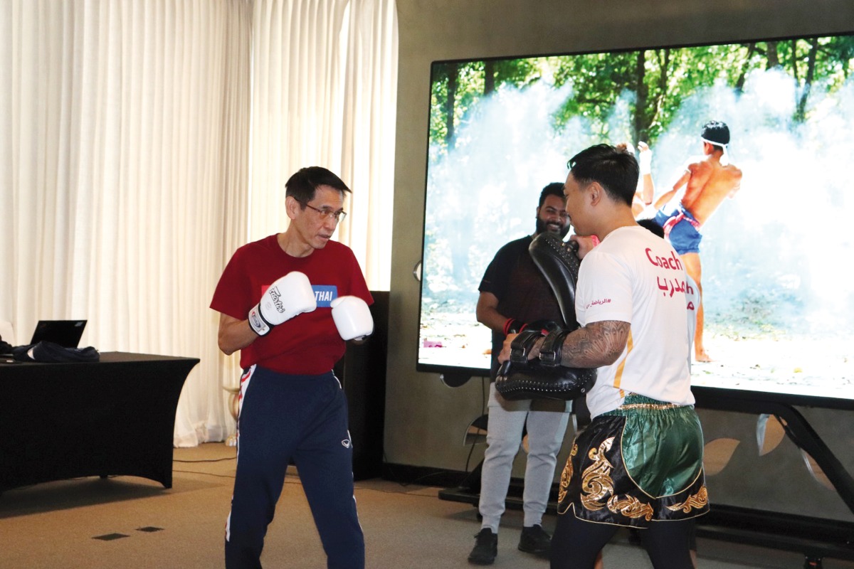 Thai Ambassador to Qatar H E Sira Swangsilpa (left) takes part in a Muay Thai demonstration session.