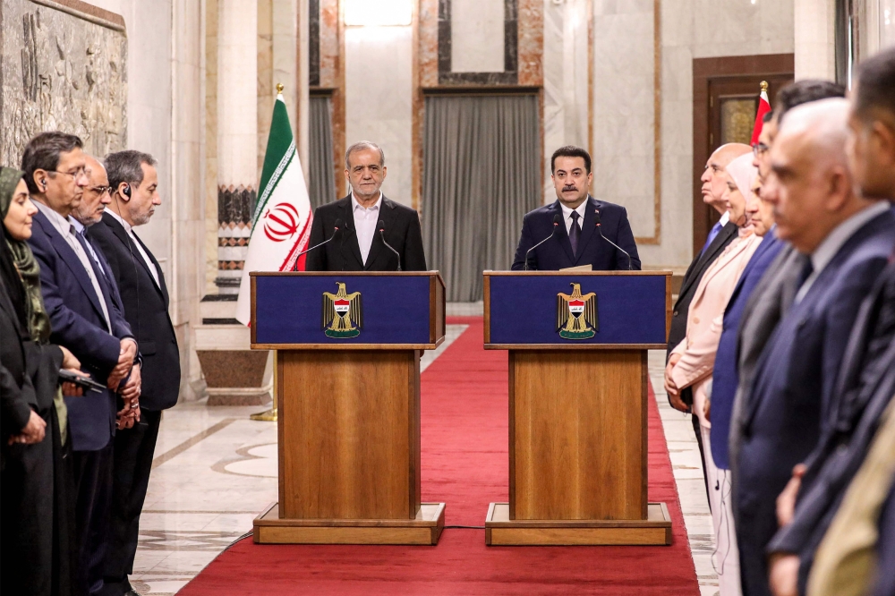 Iran's President Masoud Pezeshkian and Iraq's Prime Minister Mohammed Shia al-Sudani give a press conference after their meeting at the government palace in Baghdad on September 11, 2024. (Photo by Ahmed Jalil/ Pool / AFP)