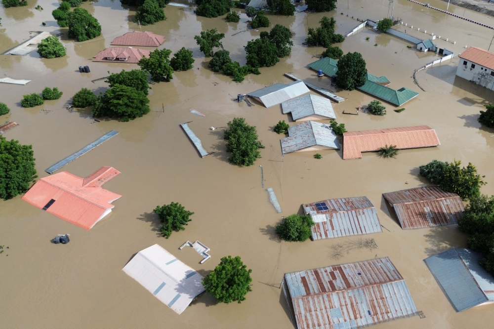 This aerial view shows houses submerged under water in Maiduguri on September 10, 2024. (Photo by Audu Marte / AFP)

