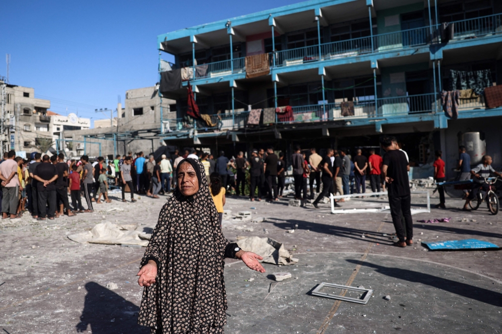 A Palestinian woman gestures at the courtyard of a school after an Israeli air strike hit the site, in Nuseirat in the central Gaza Strip on September 11, 2024. (Photo by Eyad Baba / AFP)