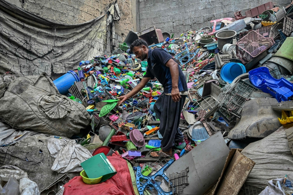  A worker sorts plastic objects at a recycling unit in Karachi on September 10, 2024. (Photo by Asif Hassan / AFP)
