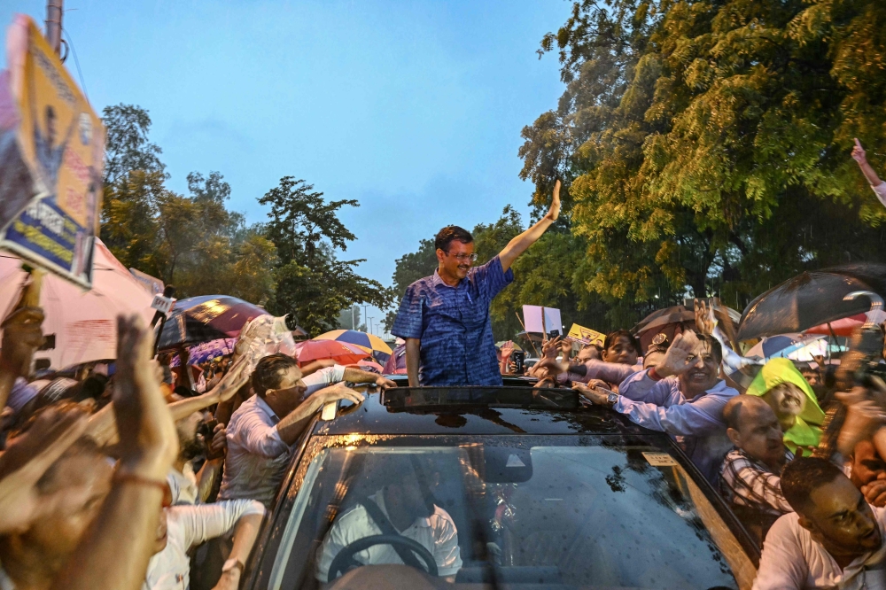 Arvind Kejriwal, Chief Minister of Delhi and leader of the Aam Aadmi Party (AAP), greets his supporters after Supreme Court granted him bail in New Delhi on September 13, 2024. (Photo by Money Sharma / AFP)