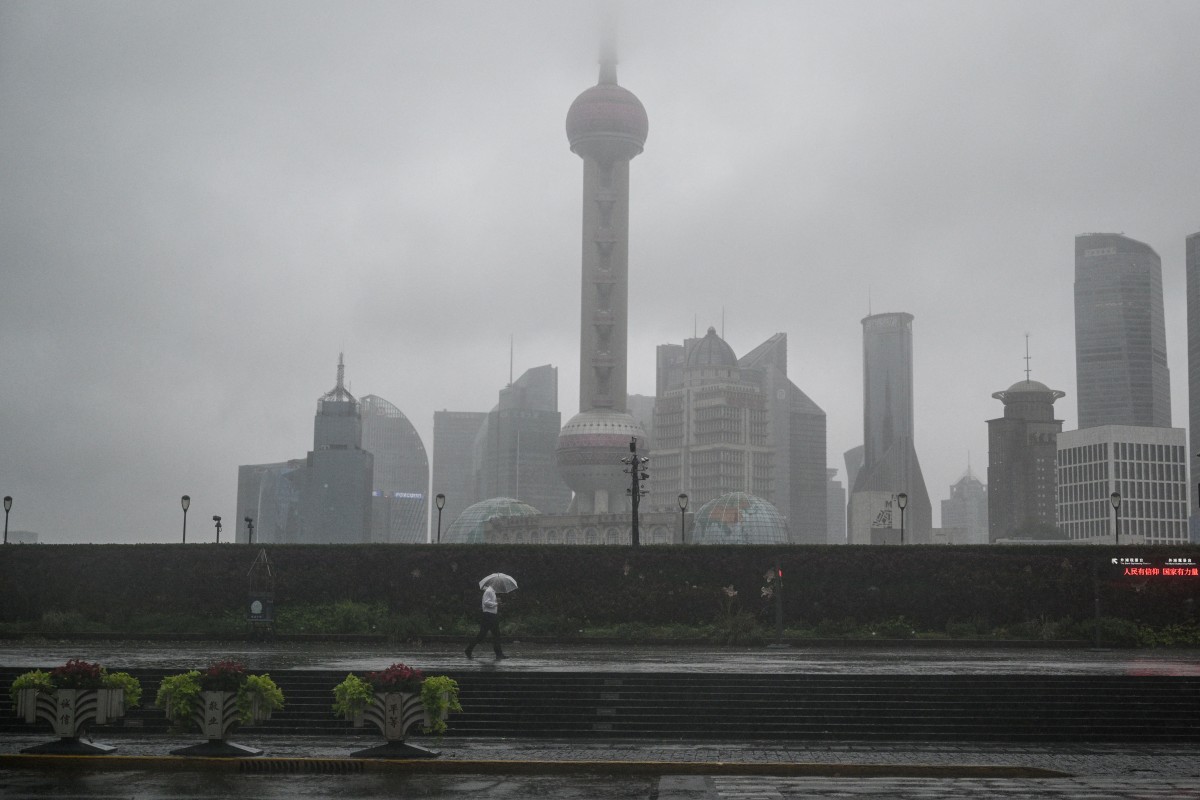 A man walks along The Bund during the passage of Typhoon Bebinca in Shanghai on September 16, 2024. Photo by Hector RETAMAL / AFP.