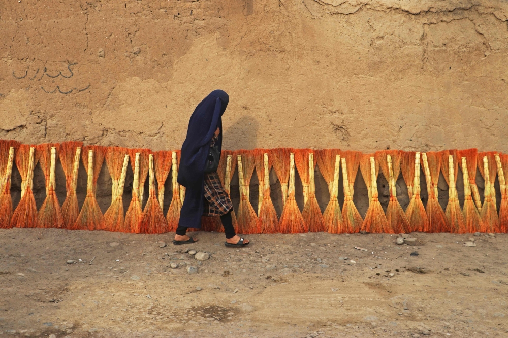 An Afghan burqa-clad woman walks along a street in Fayzabad district of Badakhshan Province on September 16, 2024. (Photo by Omer Abrar / AFP)