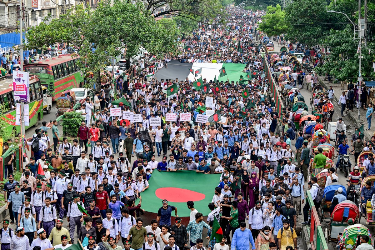 Demonstrators carry Bangladesh's national flag (front) during Martyr March, a rally organised by Students Against Discrimination to mark one month to the ousting of the country's former Prime Minister Sheikh Hasina, in Dhaka on September 5, 2024.Photo by Munir UZ ZAMAN / AFP.