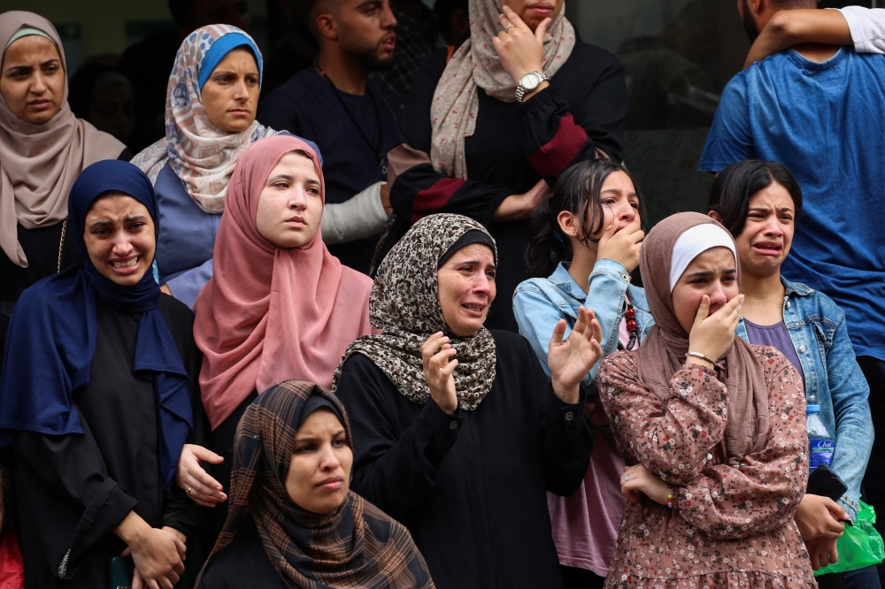 Palestinian women mourn people killed in Israeli strikes on the Bureij refugee camp, after their bodies were taken to the al-Awda Hospital at the Nuseirat refugee Camp in the central Gaza Strip on September 17, 2024. (Photo by Eyad Baba / AFP)