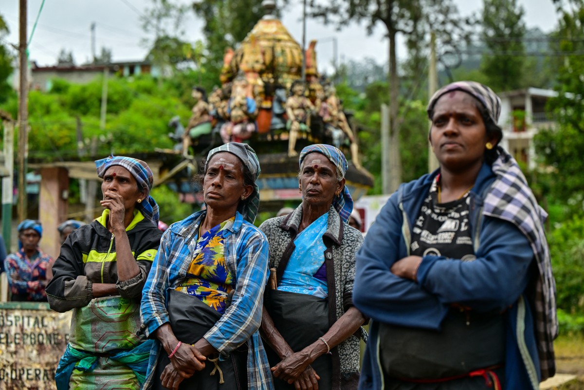 In this photograph taken on September 2, 2024, tea pickers listen to Palani Shakthivel, national organiser of the Ceylon Workers Congress (CWC), at a village in Hatton. Photo by Ishara S. KODIKARA / AFP.