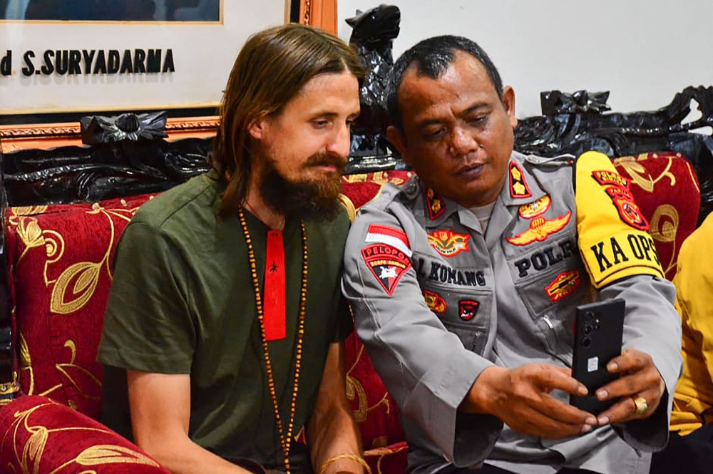 This handout taken and released on September 21, 2024 by the Cartenz Peace Task Force shows New Zealand pilot Phillip Mehrtens (L) following his release at a press conference in Timika. (Photo by Handout / Cartenz Peace Task Force / AFP) /