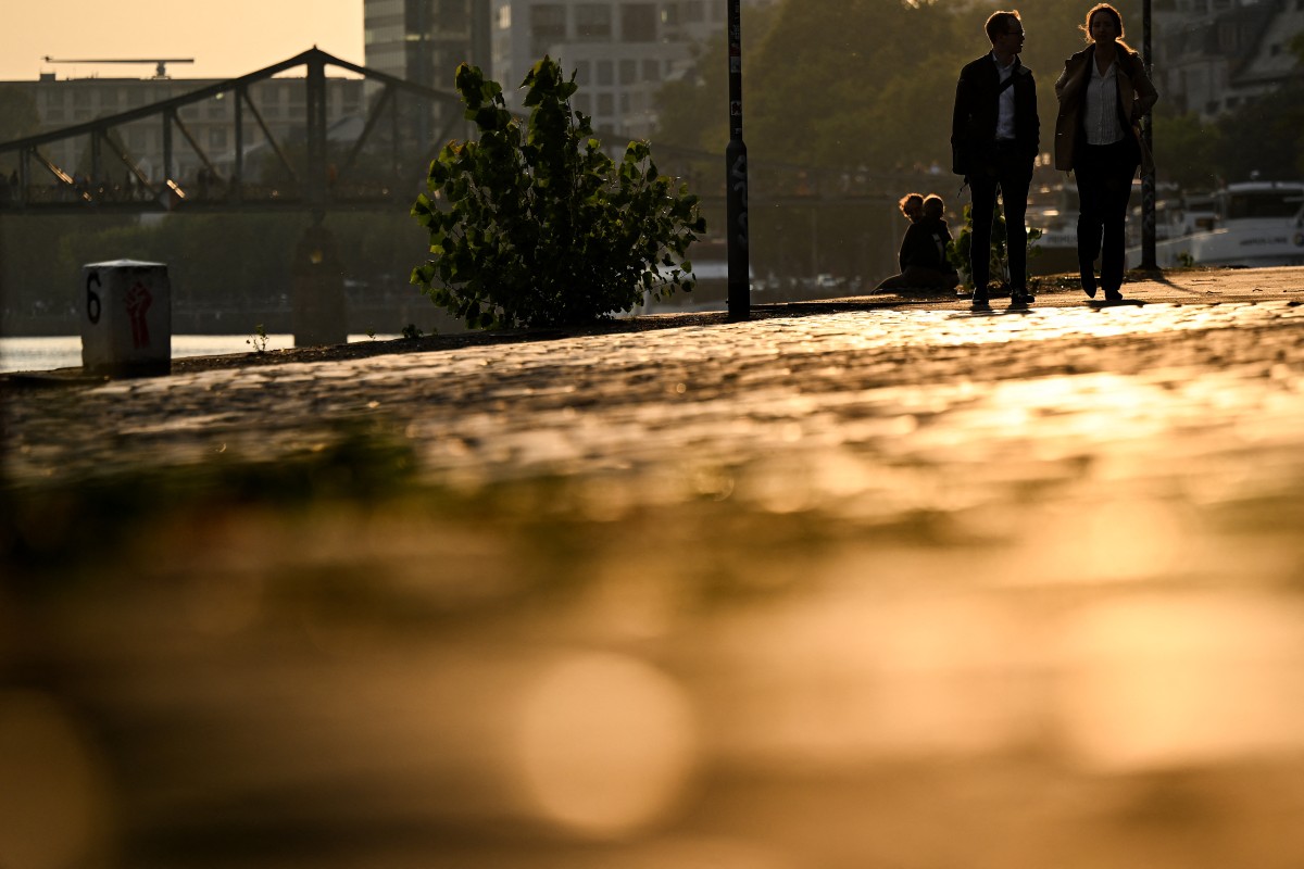 Pedestrians walk on the river Main embankment during sunset in Frankfurt am Main, western Germany, on September 18, 2024.
(Photo by Kirill KUDRYAVTSEV / AFP)
